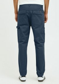 Navy cargo pants with multiple pockets, a straight-leg design, and reinforced stitching. Visible belt loops and contrast stitching details.