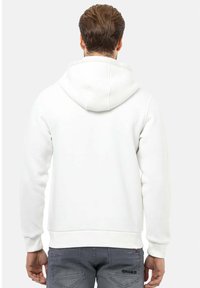 Witte hoodie met een zachte textuur, met een kangoeroezak en geribbelde manchetten. De achterkant heeft geen zichtbare branding of patronen.