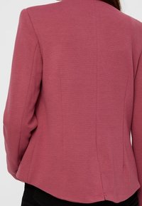 Růžový strukturovaný blazer s přizpůsobeným střihem, s jemným žebrovaným vzorem, rozparkem na zadní straně a bez viditelného kování či akcentů.