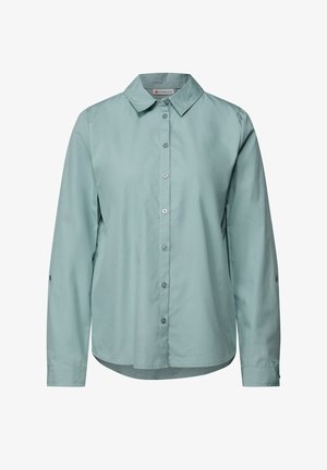 Chemise boutonnée à manches longues de couleur bleu clair en tissu lisse. Elle présente un col, un ourlet arrondi et des détails de boutons à l'avant et aux manches.