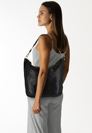 Borsa a spalla in pelle nera con una texture morbida, forma arrotondata e una lunga tracolla regolabile. Presenta dettagli in metallo dorato.
