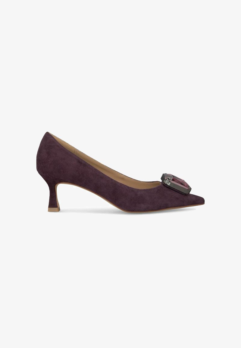 Scarpa con tacco alto in suede viola, con punta affilata; presenta un accento decorativo in gemma sulla tomaia e un tacco medio slanciato.