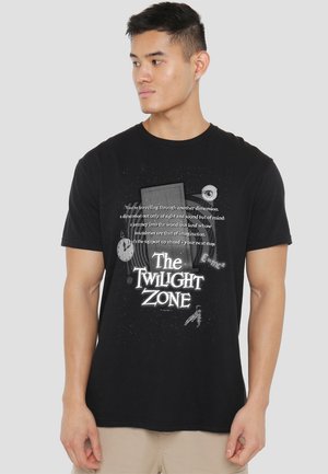 Black cotton T-shirt featuring "The Twilight Zone" graphic with white text, cosmic imagery, clocks, and an eye design. Crew neck, short sleeves.