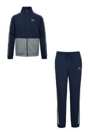 Chaqueta de chándal azul marino y gris con cremallera y logo "P1" y pantalones deportivos azul marino a juego con cordón y rayas laterales.