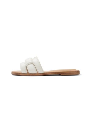 Sandalia deslizante de cuero blanco con dos correas anchas, diseño de punta abierta y suela plana de goma marrón. Textura suave y estilo minimalista.