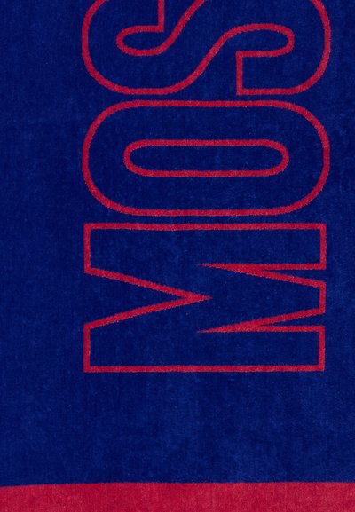 Ναυτικό μπλε ύφασμα με μεγάλα κόκκινα γράμματα με περίγραμμα που σχηματίζουν τη λέξη «MOS» κάθετα, δίπλα σε μια συμπαγή κόκκινη γραμμή στο κάτω μέρος.