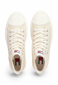Sneakers in canvas color crema con punte in gomma bianca, lacci tondi e occhielli metallici. Presentano il marchio sul tallone e sulla linguetta.