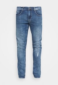 Jeans de denim azul claro con un ajuste slim, que presentan detalles desgastados, bolsillos y un cierre de botón tradicional.