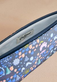 Cipzáras ceruzaeset kék szövetből, színes virág- és geometrikus mintával, sima belső résszel és látható Cath Kidston címkével.