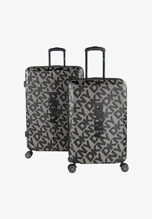 Juego de equipaje DKNY en negro y gris con un gran patrón de logo, carcasa dura y resistente, asas retráctiles y ruedas de fácil deslizamiento.