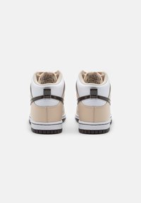 Beige and white high-top sneakers with textured leather, soft lining, and brown accents. Features a rounded toe and contrasting rubber sole.