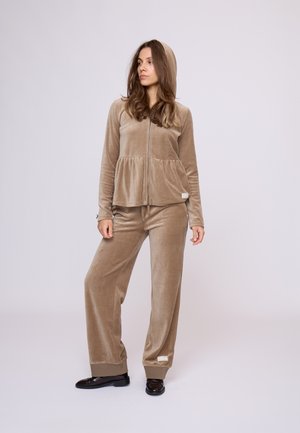Velvet-Loungewear-Set in hellbraun, bestehend aus einer Kapuzenjacke mit Reißverschluss und einem Peplum-Taille sowie passenden weit geschnittenen Hosen. Strukturierter Stoff und Bündchen.