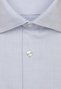 Chemise à rayures bleu clair avec un col classique et un bouton unique à surface lisse. Le tissu présente une texture diagonale.