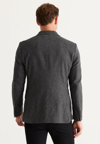 Donkere grijs wollen mix blazer met een getailleerde pasvorm, scherpe revers en een gladde textuur. Voorzien van knoopmanchetten en een gesplitste achterkant.