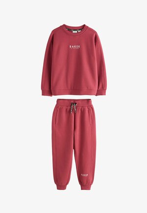 Czerwona bluza z długim rękawem i pasujące spodnie dresowe z elastycznymi mankietami, ściągaczem w pasie i napisem "BAKER by Ted Baker" na piersi i nodze.