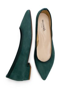 Bailarinas verdes de ante con punta afilada, que cuentan con una suela de goma y un borde elástico para un ajuste seguro. Detalles marrones en el tacón.