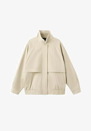 Veste beige zippée avec col haut, manches longues, ourlet élastique, détail rabat à l’avant et deux poches latérales.