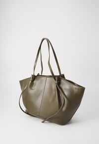 Olive vihre ä nahkainen olkalaukku, jossa on kaksi pitkää kahvaa, hieman roikkuva muotoilu, solmimisyksityiskohtia ja sileä pinta.