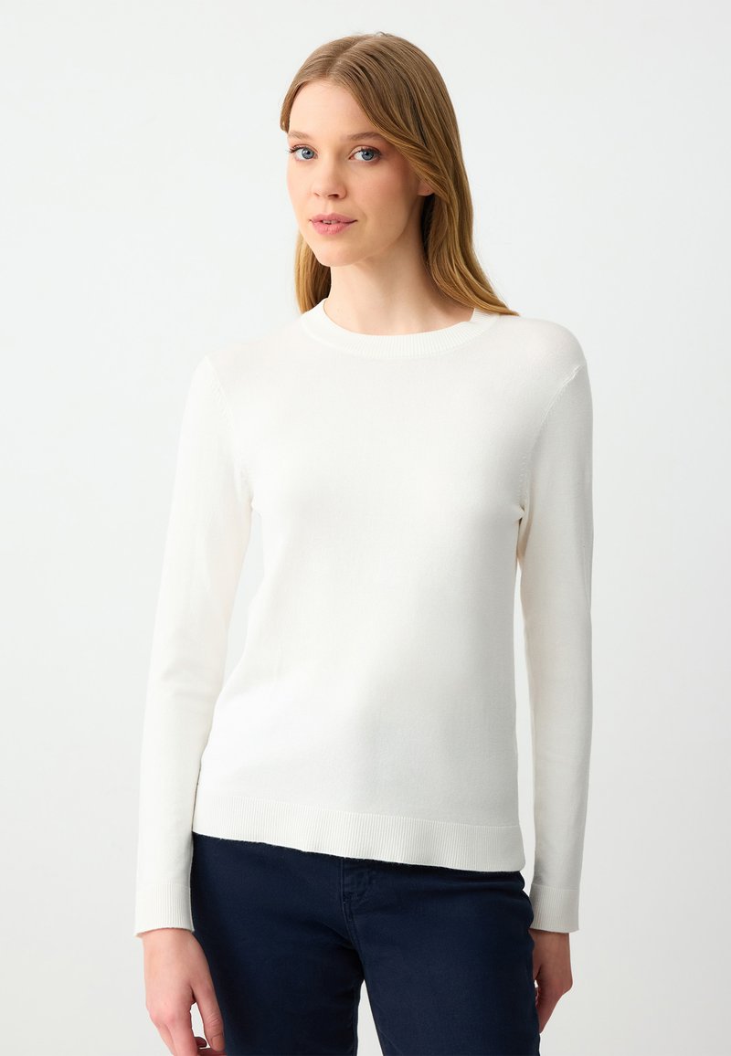 Maglione bianco a maniche lunghe con scollatura rotonda e polsini a costina, caratterizzato da una superficie liscia e una silhouette aderente.
