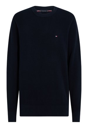 Granatowy, długi sweter z dzianiny z okrągłym dekoltem i małym czerwono-biało-niebieskim logo Tommy Hilfiger na lewej piersi.