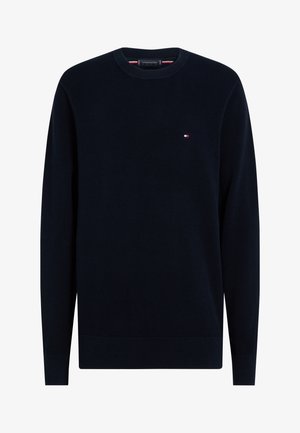 Granatowy, długi sweter z dzianiny z okrągłym dekoltem i małym czerwono-biało-niebieskim logo Tommy Hilfiger na lewej piersi.