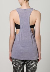 Grå ermeløs tanktop med avslappet passform, store armhull og scoop back-design, laget av et lett stoff.