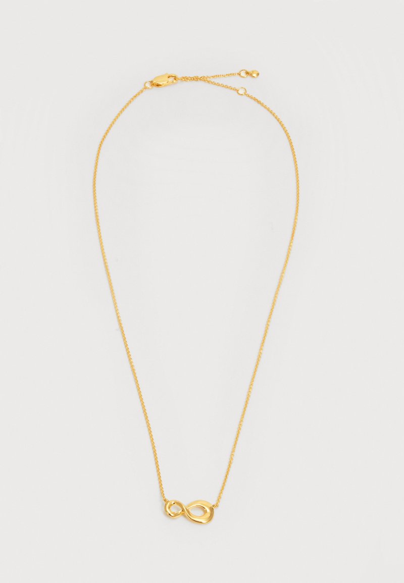 Λεπτό χρυσό κολιέ με αλυσίδα και μικρό γυαλιστερό μενταγιόν άπειρου, με ρυθμιζόμενο κούμπωμα σε λευκό φόντο.