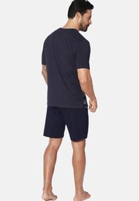 Navy blue short-sleeve t-shirt with round neckline and matching shorts. Lightweight fabric with a smooth texture and relaxed fit.