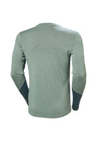 Dlouhý rukáv košile světle zelené barvy se strukturovanou tkaninou. Obsahuje tmavě modré akcenty na ramenou a rukávech, s detaily prošívání.