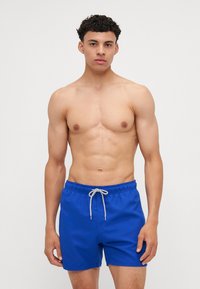 Shorts de bain bleus en tissu léger, avec une taille élastique et un cordon de serrage, dotés d'un design simple et uni.