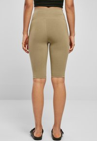 Fietsshorts in licht kaki, gemaakt van rekbare stof. Hoge taille met een gladde afwerking en gestikte zoom, met een nauwsluitende pasvorm.