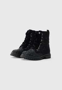 Botines negros de tobillo con acabado texturizado y brillante, puntera redonda, diseño con cordones de terciopelo y suela de goma resistente.