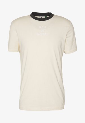 Bawełniana koszulka w kolorze ecru z czarnym prążkowanym okrągłym dekoltem. Na przodzie białe, wypukłe logo "RAW BY G-STAR". Krótkie rękawy i prosty krój.