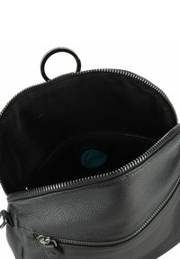 Bolso de cuero negro con un acabado texturizado, que cuenta con un cierre de cremallera, un asa circular y un interior forrado con una etiqueta de la marca.