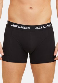 Miesten mustat bokserit, joissa on muotoiltu design ja pehmeä pinta. Varustettu leveällä joustavyötäröellä, jossa on valkoinen "JACK & JONES" -logo.