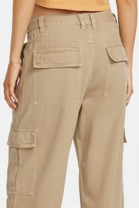 Beige cargo pants featuring a mid-rise waist, large flap pockets at the back, and a relaxed fit. Smooth texture with reinforced stitching.