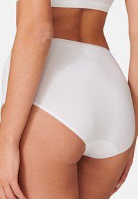 Weiße Baumwollunterwäsche mit hoher Taille, matte Textur, nahtloses Design und glatter Taillenbund, der einen klaren und schlichten Look akzentuiert.