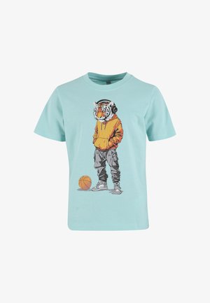 T-shirt bleu clair avec une silhouette à tête de tigre portant un sweat à capuche orange, un pantalon gris, des écouteurs, debout à côté d’un ballon de basket.
