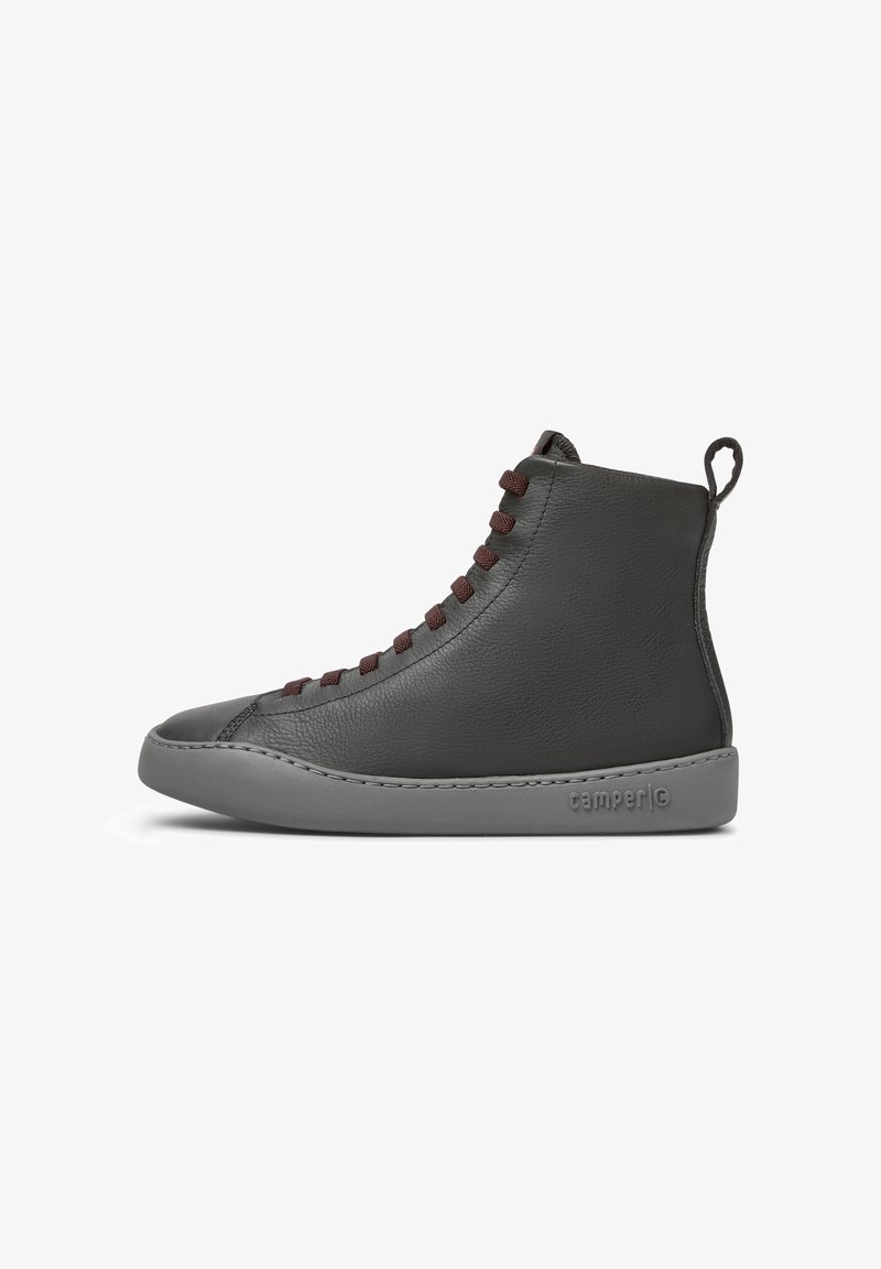 Baskets montantes en cuir noir avec des lacets rouge foncé, une semelle en caoutchouc grise et une languette au talon, vue latérale.