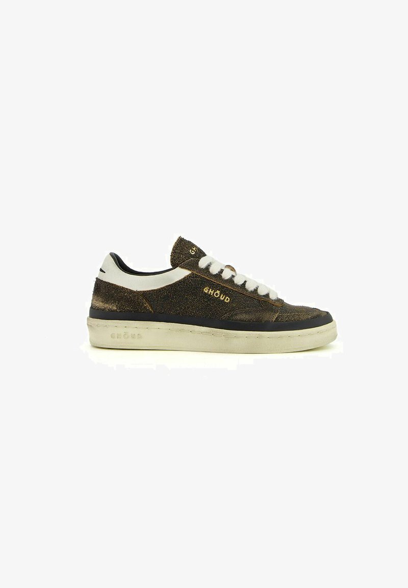 Sneaker marrone con texture, dettagli e lacci bianchi, suola nera e logo dorato. Punta arrotondata e design a profilo basso.