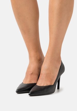 Scarpe nere con tacco alto in pelle liscia, caratterizzate da una punta affusolata e un design elegante. Elevazione fornita da un tacco sottile.