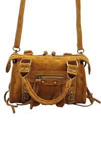 Sac en suède tan avec deux poignées supérieures, une sangle réglable et une poche zippée à l'avant avec des accents en laiton.