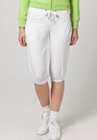 Vita capribyxor med dragsko i midjan, framfickor och elastiska muddar. Slät textur, lättviktig tyg som passar för avslappnad användning.