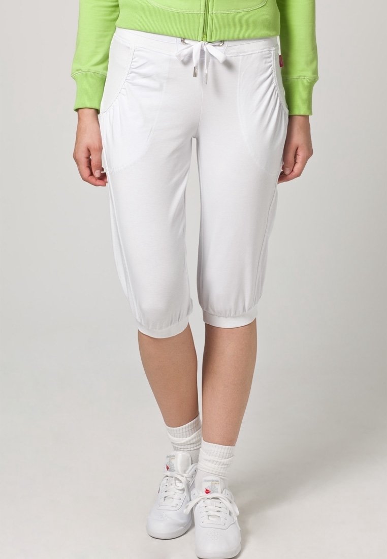 Vita capribyxor med dragsko i midjan, framfickor och elastiska muddar. Slät textur, lättviktig tyg som passar för avslappnad användning.