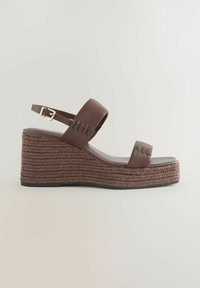 Brown wedge sandal with a thick rope sole and two straps, one adjustable. It features a sleek design suitable for casual or dressy occasions.