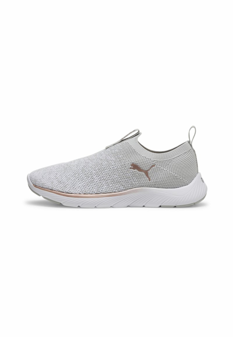 Gaiši pelēki slip-on sporta apavi ar teksturētu adītu augšdaļu, balta gumijas zole un smalka metalliska logo akcenta puse.