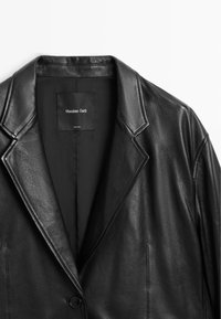 Černá kožená bunda s klopovým límcem, zapínání na jeden knoflík a hladkou texturou. Štítek uvnitř hlásí "Massimo Dutti."