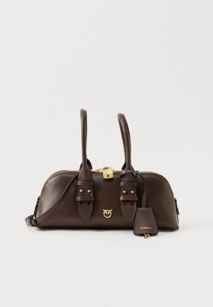 Tumši brūns ādas rokassomas ar divām rokturiem, zelta rāvējslēdzis un atslēga, dekoratīvs zelta logotips un atbilstoša atslēgu piekariņa birka ar zīmola nosaukumu.