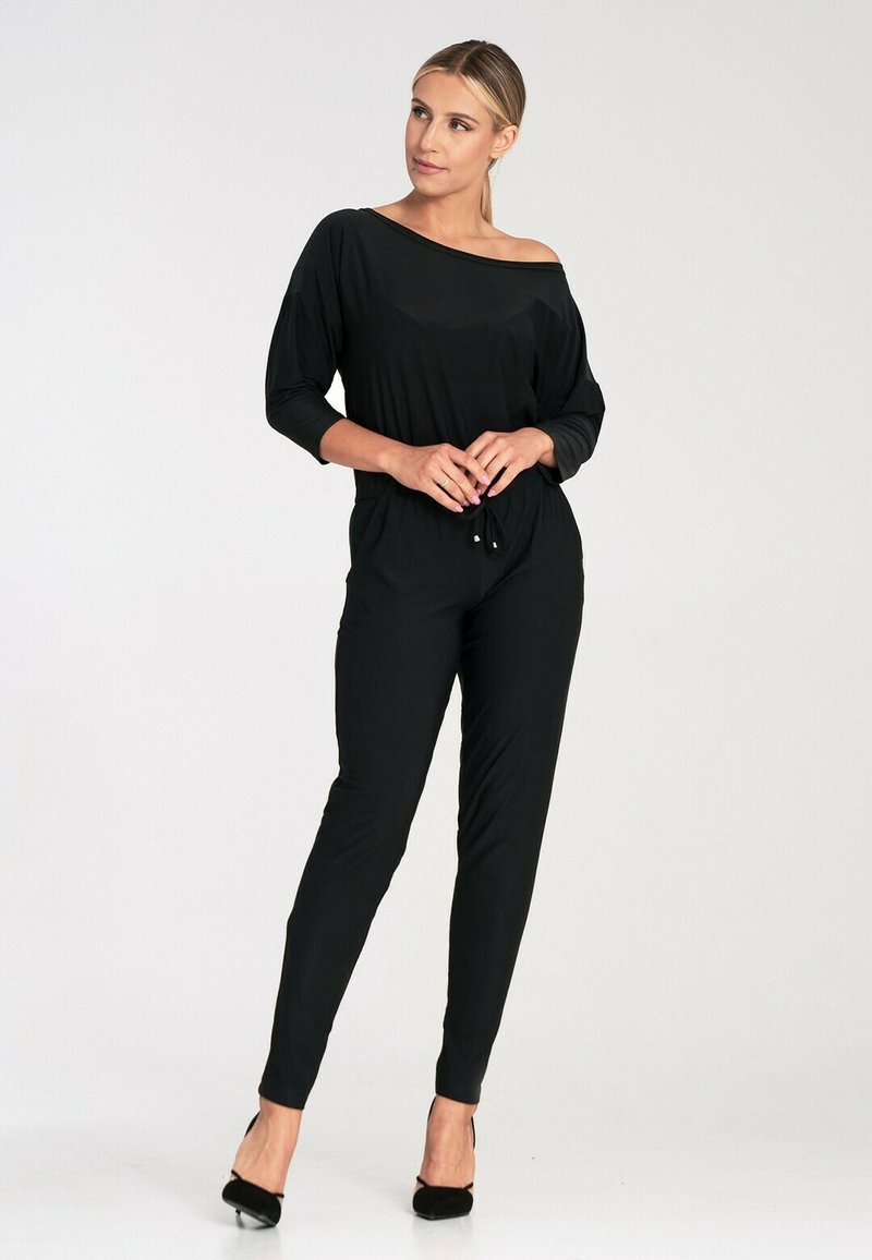 Czarny kombinezon z regulowanym w pasie, dekoltem hiszpańskim i rękawami o długości 3/4. Gładki, lekki materiał i zwężane nogawki.