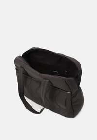 Černá prošívaná kabelka s dvěma dlouhými uchy a zipovým uzávěrem. Viditelná vnitřní kapsa, hladký povrch, jemný materiál a zaoblený tvar.